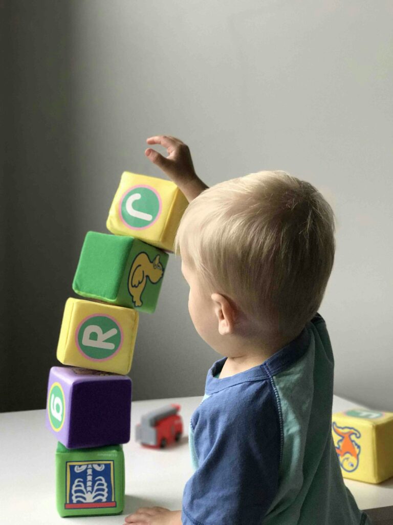 Litet barn som bygger ett torn av mjuka klossar